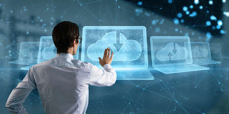 Attractive young caucasian businessman with abstract polygonal digital laptop with cloud computing...