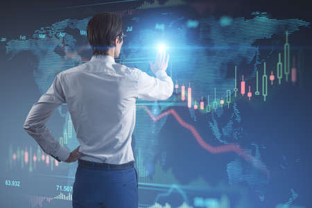 Stock market and trading concept with man back view touching digital wall screen with world map and...