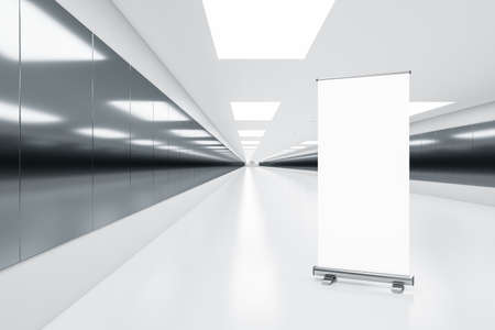 Modern white underground corridor with empty white roll up banner for advertisement, ceiling lights....