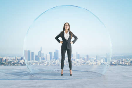 Attractive happy european businesswoman with folded arms standing under and inside big glass sphere...