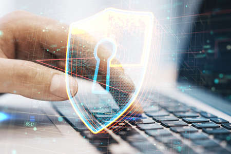 Cyber security concept with digital shield and keyhole inside icon on man hand typing on laptop...