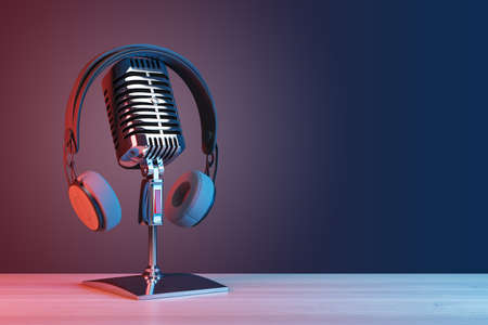 Podcasting and radio concept with retro microphone and headphones on empty wooden table and dark blank wall background with place for your logo or text. 3D rendering, mock upの写真素材