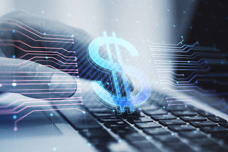 Close up of hands using laptop with glowing dollar hologram and lines on blurry background....
