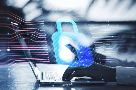 Close up of hands using laptop keyboard with glowing padlock hologram and lines on blurry outdoor...