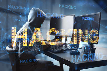 Cyber attack and hacking concept with faceless hacker in hoody in front of computers and glowing...
