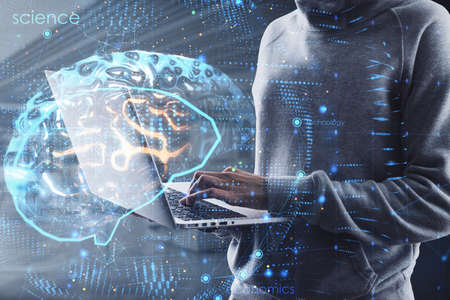 Hacker using laptop with creative brain hologram on blurry office interior background. Science,...