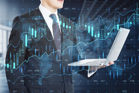 Attractive thoughtful young european businessman with laptop and creative glowing forex chart...