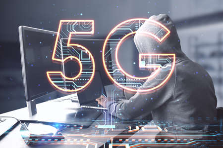 Side view of hacker hands using computers at desktop with creative 5G hologram on blurry office...