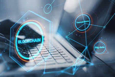 Close up of hands using laptop keyboard with creative polygonal blockchain hologram on blurry...
