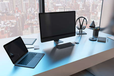 Close up of creative designer workplace with empty black mock up computer monitor laptop and supplies in modern office with window and panoramic city view. 3D Renderingの写真素材