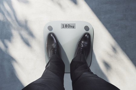 Close up and top view of man feet on scales asking for help. Lose weight and measuring conceptの写真素材