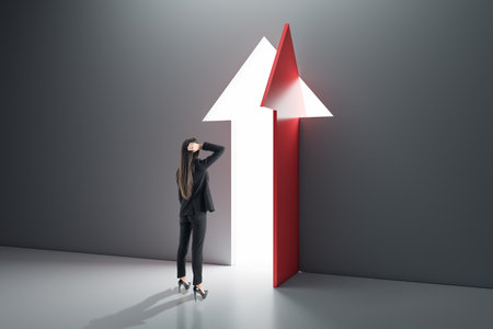 Back view of thoughtful businesswoman standing in interior with open arrow door. Success, business and opportunity conceptの写真素材