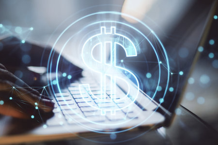 Close up of hands using laptop computer with creative glowing dollar hologram on blurry backround. Futuristic hi-tech digital money and electronic economy of the future concept. double exposureの写真素材