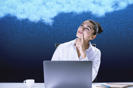 Attractive young european businesswoman at desktop with laptop on blurry digital blue background...