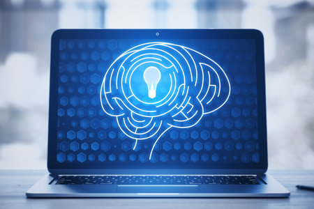 Close up of laptop keyboard with digital light bulb with human brain inside glowing on blurry blue...