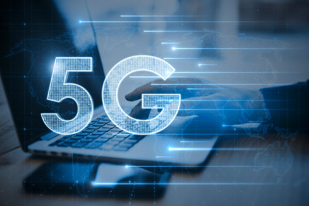 Close up of hands using laptop with glowing 5G hologram on blurry background. Wireless internet and web speed conceptの写真素材