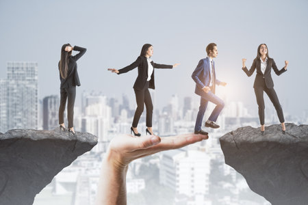 Modern image of team helping each other walk through difficulty on abstract city background with cliff gap. Teamwork, help, success and union conceptの写真素材