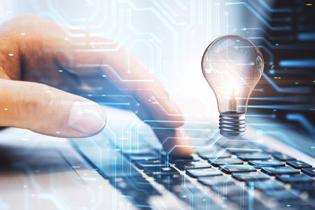 Close up of man hands using laptop with abstract circuit and lamp hologram on blurry background. Digital idea and data concept. double exposureの写真素材