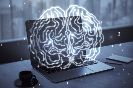 Close up of laptop computer on desktop with coffee cup and glowing human brain hologram on screen...
