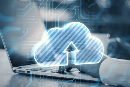 Close up of businessman hands using laptop with glowing cloud hologram on blurry outdoor background....