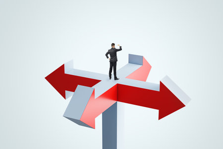 Goal, aim at target and decision concept with looking into the distance businessman staying on crossroads of red and gray arrows on abstract light backgroundの写真素材