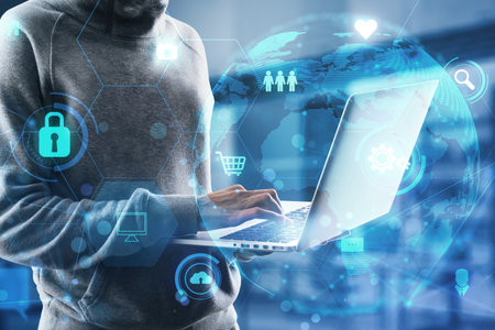 Hacker using laptop keyboard with glowing globe and business icons hologram on blurry office interior background. Global network, data theft, fishing and data exchange concept. double exposureの写真素材