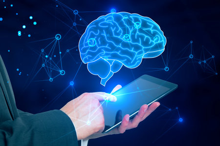 Close up of businessman hand using tablet with glowing human brain hologram on blurry background....