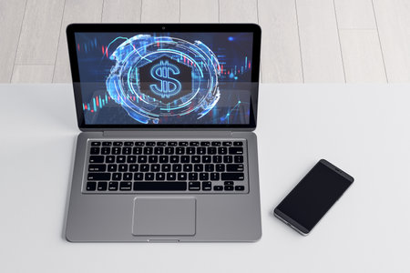 Top view of laptop computer and cellphone on desktop with glowing dollar hologram on white background. Money, digital banking and finance concept. 3D Renderingの写真素材