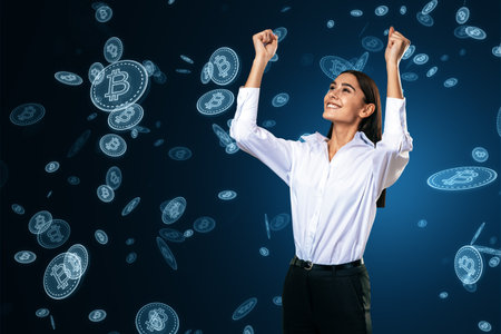 Happy young european female with falling digital bitcoins on blue background. Success, cryptocurrency exchange and money conceptの写真素材