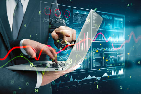 Close up of businessmen hands using laptop with glowing business chart hologram hud screen on blurry...