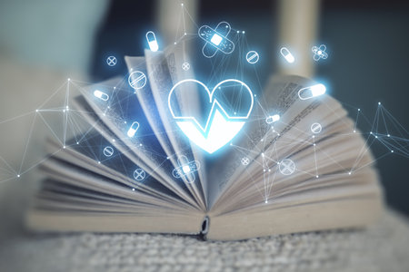 Close up of open book with glowing heart hologram on blurry background. Cardiology and doctor's office concept. double exposureの写真素材