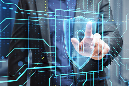 Close up of male hand pointing at glowing safety and security circuit padlock shield hologram on...