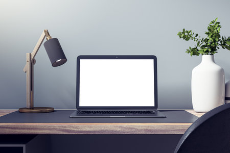 Close up of empty white laptop on wooden desk with decorative vase and plant, lamp and mock up place on concrete wall background. Designer workspace concept. 3D Renderingの写真素材