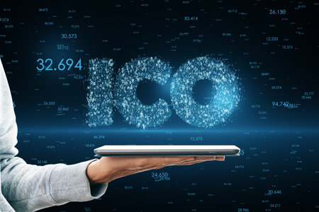 Close up of female hand holding smartphone with glowing ICO hologram. Initial coin offering and...