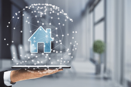 Close up of businessman hand holding cellphone with polygonal sphere with house hologram on blurry office interior background. digital home concept. double exposureの写真素材