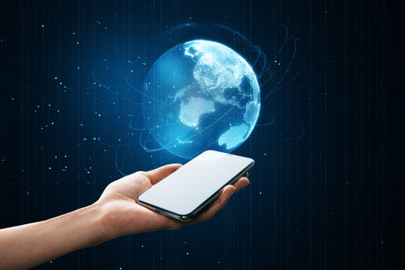 Close up of woman hand holding empty white mock up cellphone with glowing blue polygonal globe on blurry background. global technology and metaverse conceptの写真素材