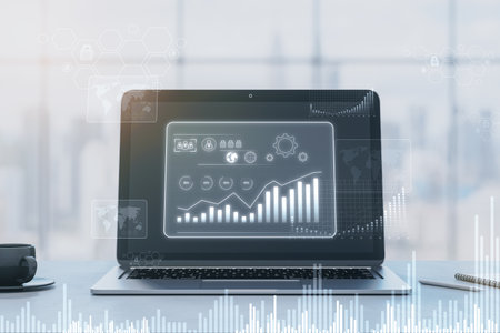 Close up of laptop at office workplace with glowing business chart hologram on blurry window with...
