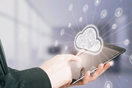 Close up of businessman hand using cellphone with digital white cloud hologram with various icons on...