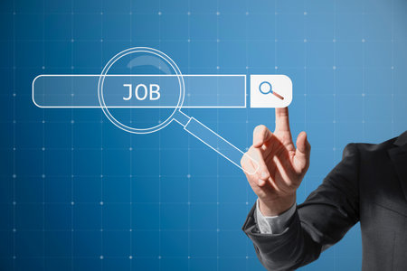 Recruitment hiring technology and human resources concept with man finger on virtual touch screen with digital magnifying glass on job search bar on abstract blue backgroundの写真素材