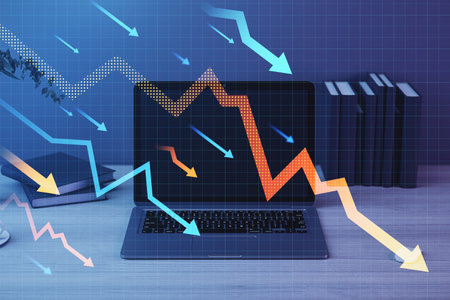 Close up of laptop on office desk with falling arrows and map on blurry background. Stock or...