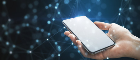 Close up of female hand holding white cellphone with creative glowing blurry plexus on dark...