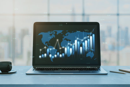 Close up of laptop at office desk with coffee cup and creative business chart, map and index on blurry window city view background. Financial growth, global business and data concept. 3D Renderingの写真素材