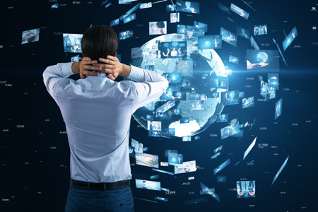 Back view of stressed young european businessman looking at creative globe with telecommunication picture icons on blurry blue background. Business, video conference, remote group workの写真素材