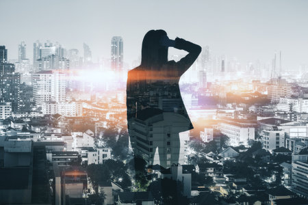 Back view of thoughtful businesswoman silhouette standing on dark night city background. Success, work and lifestyle concept. double exposureの写真素材