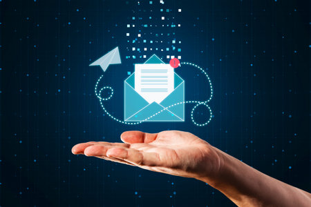 Online communication, letter, email and newsletter concept with paper list in blue envelope with paper airplane flying around above man hand palm on abstract dark backgroundの写真素材