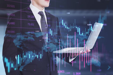 Headless busiessman using laptop with glowing candlestick forex chart on blurry office interior...