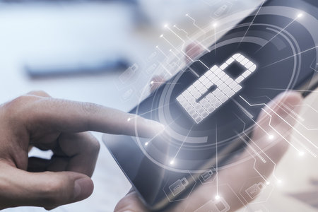 Close up of male hands using tablet at office workplace with glowing circuit padlock hologram on blurry background. Secure and safety concept. double exposureの写真素材