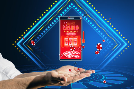 Online casino and gaming, gambling on device concept. Close up of male hands holding smartphone with creative slot machine and other gamesの写真素材