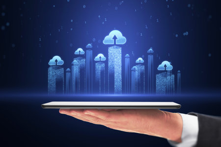 Data storage and cloud computing service concept with blue glowing city skyscrapers visualization with cloud icons above digital tablet in businessman hand on dark backgroundの写真素材