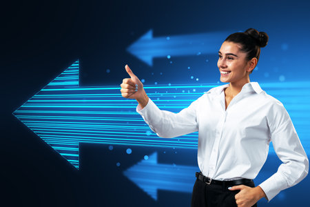 Side view of attractive happy european businesswoman showing thumbs up to glowing digital arrow made up of blue tech lines on dark background. Market, technology and top conceptの写真素材